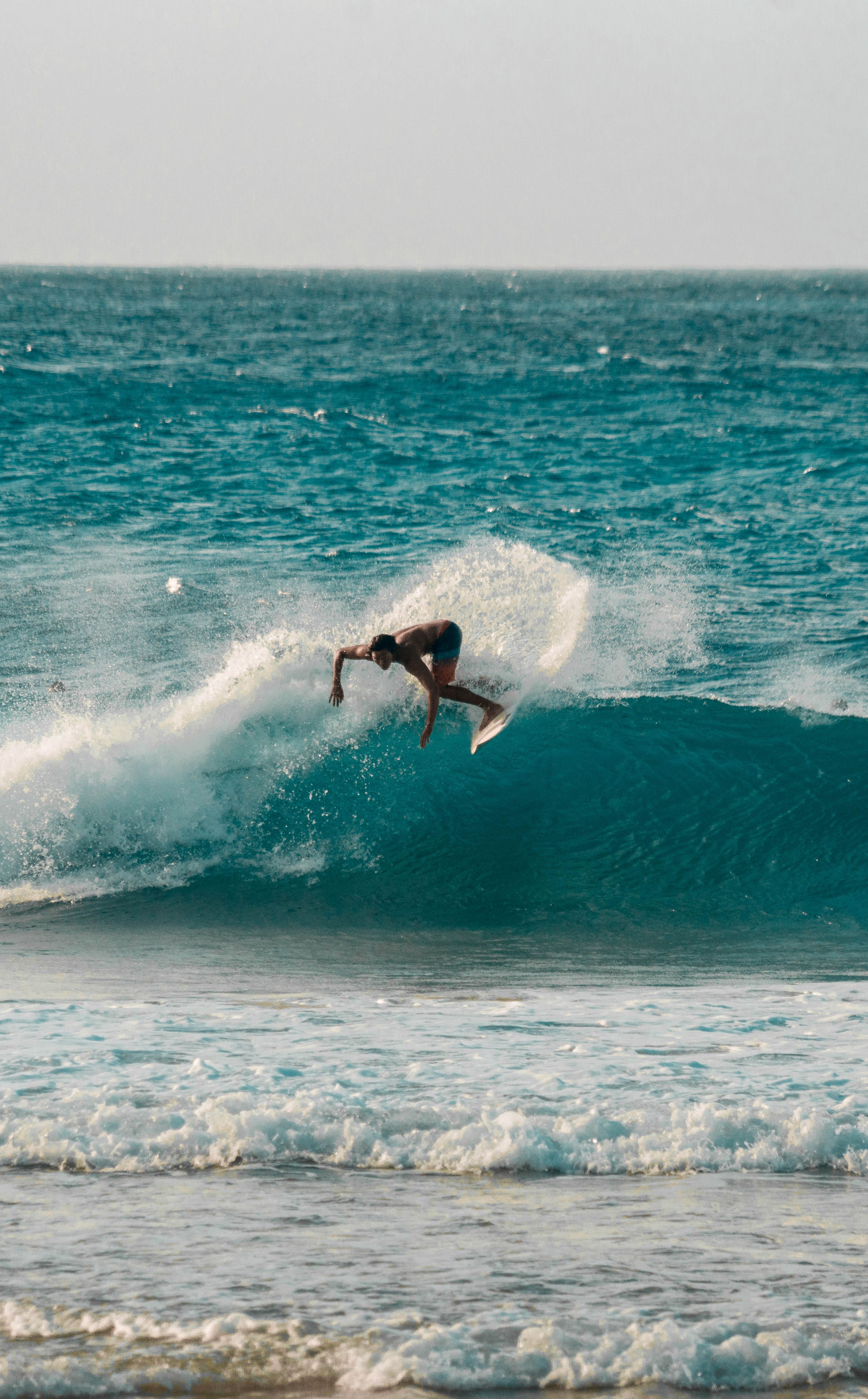Surfers at Batu Bolong Beach Canggu at golden hour with long waves