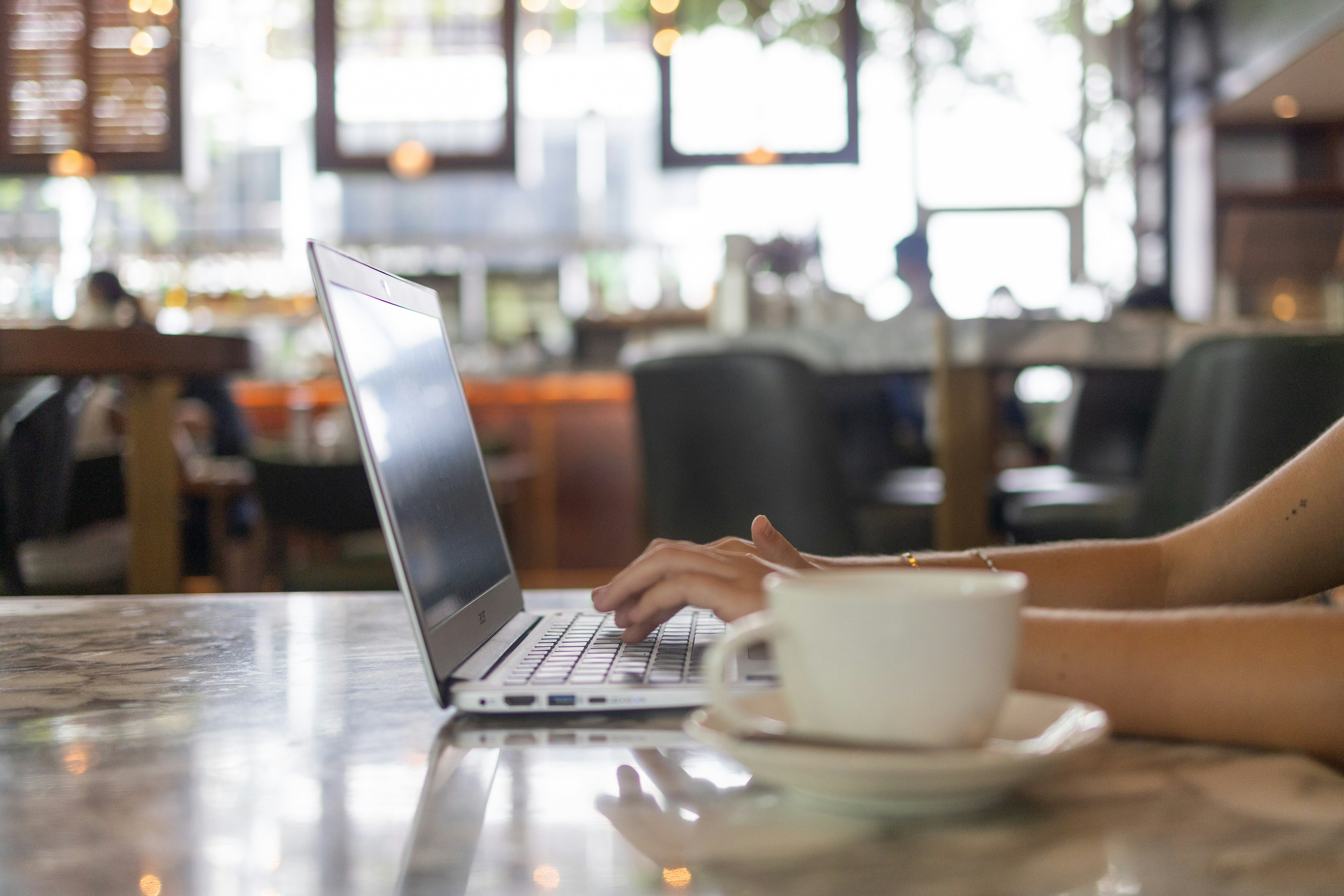 Digital nomad working on laptop in a café in Canggu Bali with tropical garden view